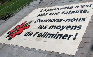 Photographie d'un casse-tête géant où il est écrit « La pauvreté n'est pas une fatalité. Donnons-nous les moyens de l'éliminer ». 