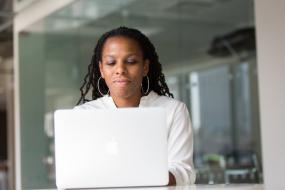 Photographie d'une femme racisée utilisant un ordinateur portable.