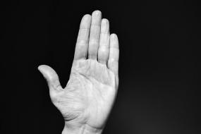 Photographie en noir et blanc d'une main, la paume vers l'objectif.