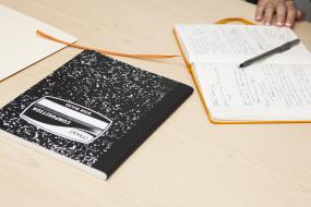 un carnet et des papiers et crayons sur une table