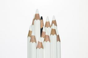 Photographie de crayons blanc debouts. Un crayon noir se trouve partiellement caché.