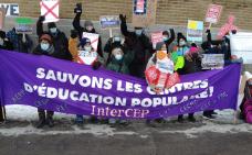 Photo de groupe de participants et participantes de la manifestation. Une bannière où il est écrit Sauvons les centres d'éducation populaire! est tenue au centre du groupe.