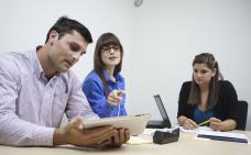 trois personnes travaillent à une table