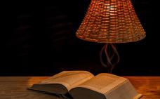 un livre ouvert et une lampe sur une table