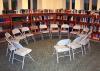 Photographie de l'intérieur d'une bibliothèque où des chaises sont placées en rond.