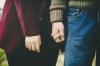 Photographie en gros plan d'un couple qui se tient par la main.