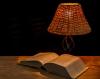 un livre ouvert et une lampe sur une table