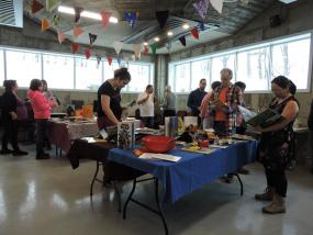Des gens consultent des livres sur plusieurs tables dans une grande salle
