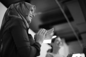 Photographie en noir et blanc d'une femme qui applaudit.