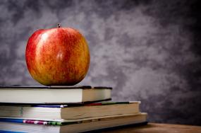 Sur une pile de livres, une pomme.