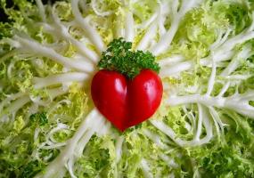 Photographie d'un coeur au milieu de verdures.