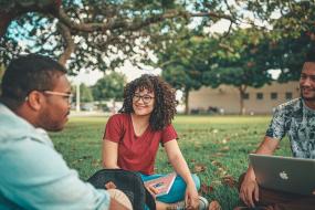 Photographie d'étudiant-e-s assis sur l'herbe.