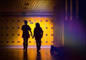 Photographie de deux élèves marchant dans le corridor d'une école.