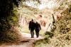 Photographie d'un couple de personnes âgées qui marchent sur un sentier de campagne.