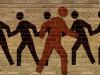 Illustration sur un mur de brique de pictogrammes noirs représentant des personnes allant dans le même sens. En avant-plan, un pictogramme orange représentant une personne se dirige dans le sens opposé.